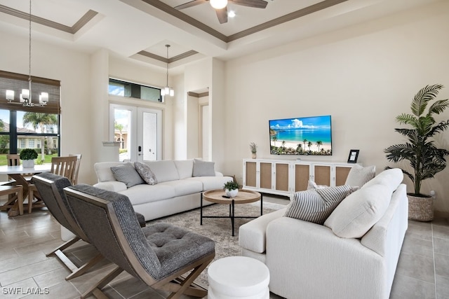 living room with ceiling fan with notable chandelier, ornamental molding, french doors, and a high ceiling