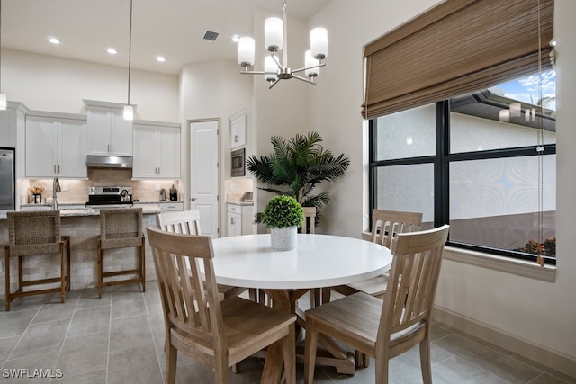 tiled dining space with sink and a chandelier