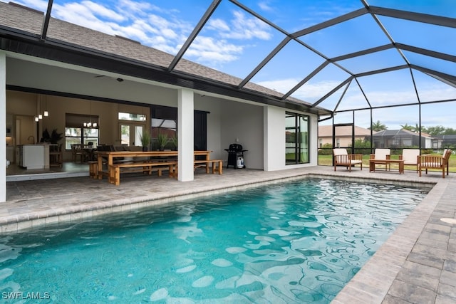 view of pool featuring grilling area, a patio, and glass enclosure