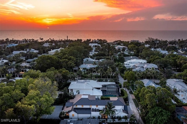 aerial view at dusk featuring a water view