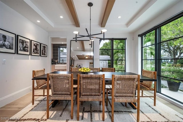 dining room with an inviting chandelier, light hardwood / wood-style flooring, and beamed ceiling