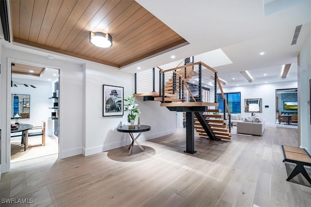 interior space with hardwood / wood-style flooring, a raised ceiling, and wooden ceiling