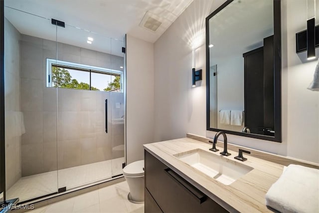 bathroom featuring toilet, a shower with door, vanity, and tile patterned floors