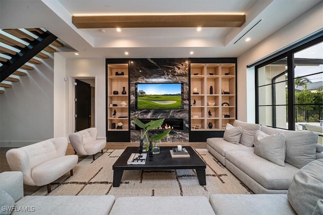 living room featuring light hardwood / wood-style floors, a premium fireplace, and built in shelves