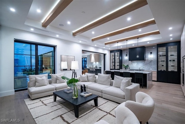 living room featuring light wood-type flooring and beamed ceiling