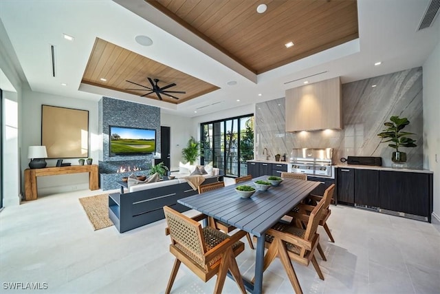 tiled dining room with a raised ceiling, ceiling fan, and wooden ceiling