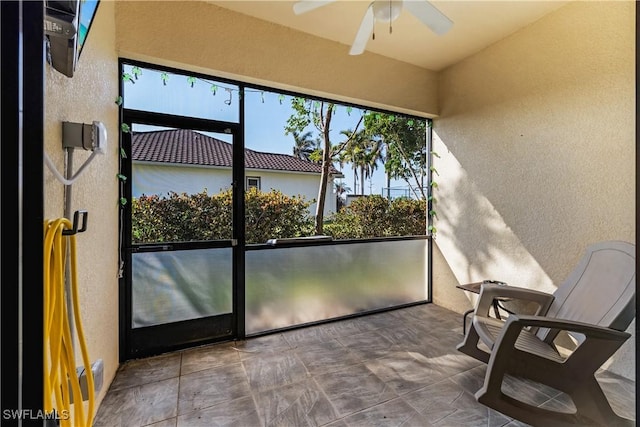 unfurnished sunroom featuring ceiling fan