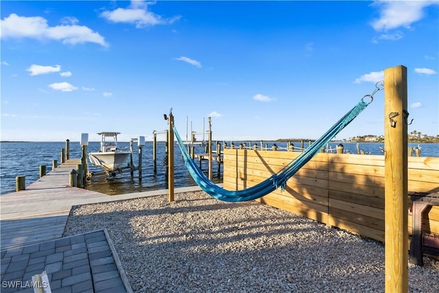 view of playground featuring a dock and a water view