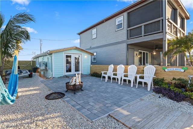 rear view of house with an outdoor fire pit, french doors, a patio area, and an outbuilding