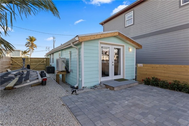 view of exterior entry featuring ac unit, a patio, and french doors