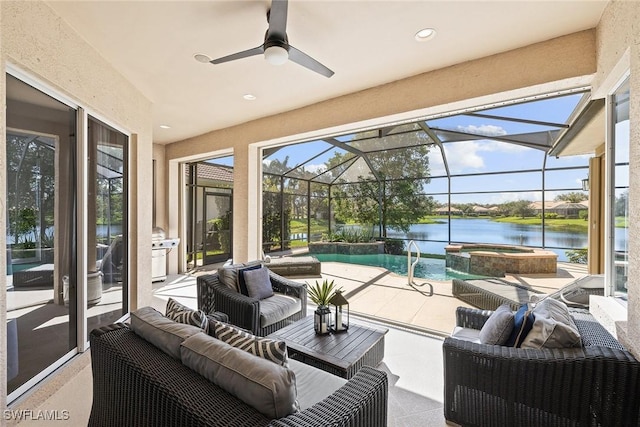 sunroom with ceiling fan and a water view