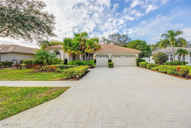 mediterranean / spanish-style home with a garage and a front yard