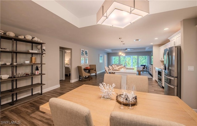 dining space with ceiling fan and dark wood-type flooring