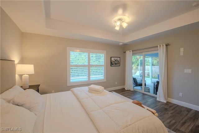 bedroom featuring access to outside, a raised ceiling, ceiling fan, and dark wood-type flooring