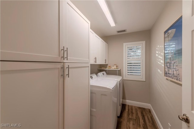 laundry area featuring cabinets, independent washer and dryer, and dark wood-type flooring