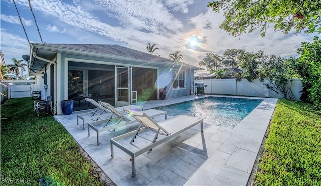 view of pool with a patio area and a yard