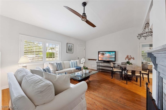 living room with a fireplace, ceiling fan, hardwood / wood-style floors, and lofted ceiling