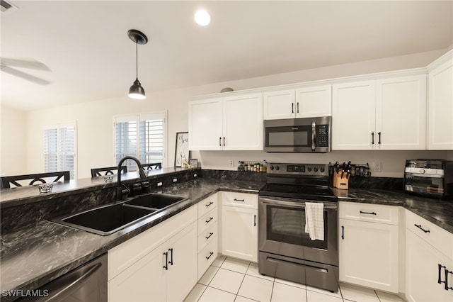 kitchen with appliances with stainless steel finishes, a sink, and white cabinets