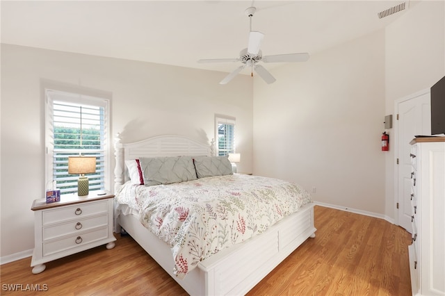 bedroom with wood finished floors, visible vents, and multiple windows