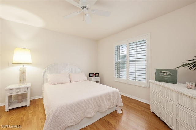 bedroom with a ceiling fan, light wood-style flooring, and baseboards