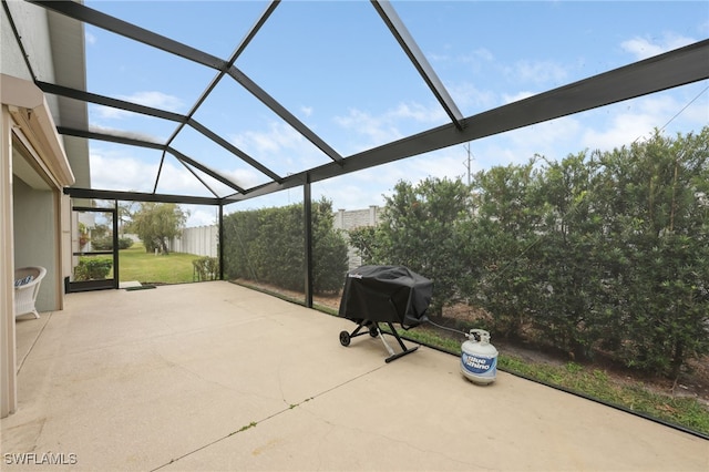 view of patio featuring glass enclosure and area for grilling