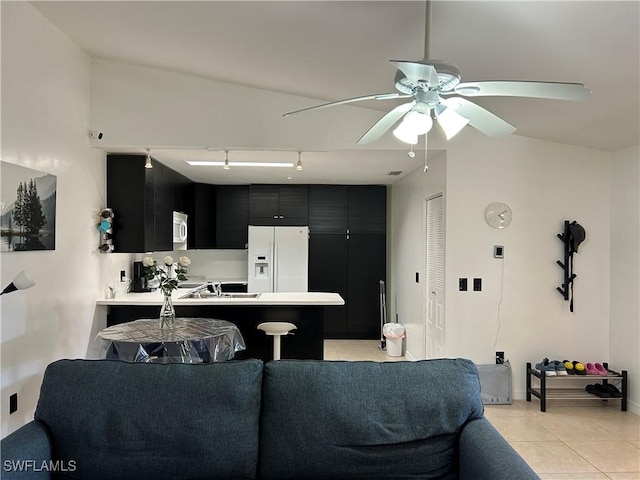 kitchen featuring kitchen peninsula, a breakfast bar area, ceiling fan, light tile patterned flooring, and white refrigerator with ice dispenser