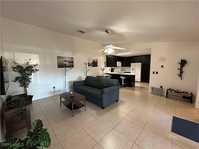 living room with ceiling fan, light tile patterned floors, and lofted ceiling