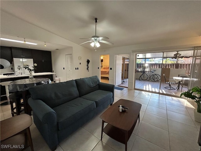 tiled living room featuring ceiling fan and vaulted ceiling