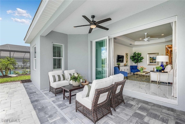 view of patio featuring an outdoor living space, glass enclosure, and ceiling fan