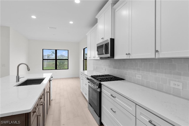 13617 Heritage Preserve Dr, Fort Myers, FL 33905 - kitchen with stainless steel appliances, a sink, light wood-type flooring, recessed lighting, and tasteful backsplash