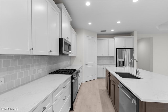 13617 Heritage Preserve Dr, Fort Myers, FL 33905 - kitchen with stainless steel appliances, a sink, recessed lighting, white cabinets, and light wood-style floors