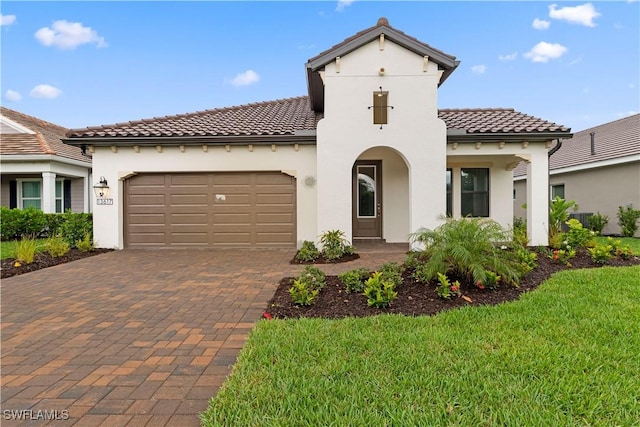 13617 Heritage Preserve Dr, Fort Myers, FL 33905 - mediterranean / spanish house featuring a tile roof, decorative driveway, stucco siding, an attached garage, and a front yard
