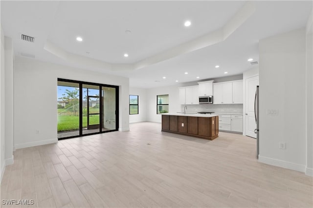 13617 Heritage Preserve Dr, Fort Myers, FL 33905 - kitchen with a tray ceiling, appliances with stainless steel finishes, open floor plan, baseboards, and an island with sink
