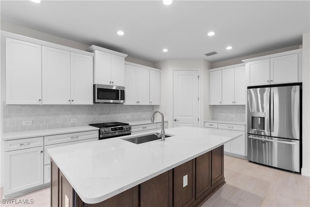13617 Heritage Preserve Dr, Fort Myers, FL 33905 - kitchen with appliances with stainless steel finishes, a sink, white cabinetry, an island with sink, and recessed lighting