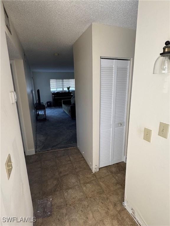 hall featuring a textured ceiling