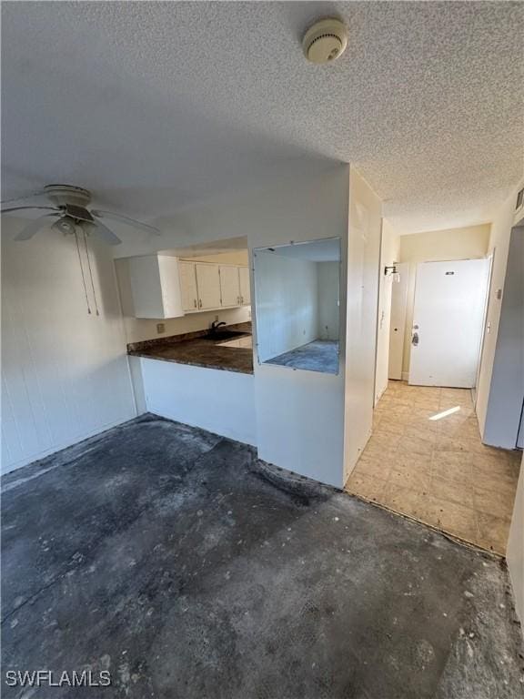 kitchen featuring ceiling fan and a textured ceiling