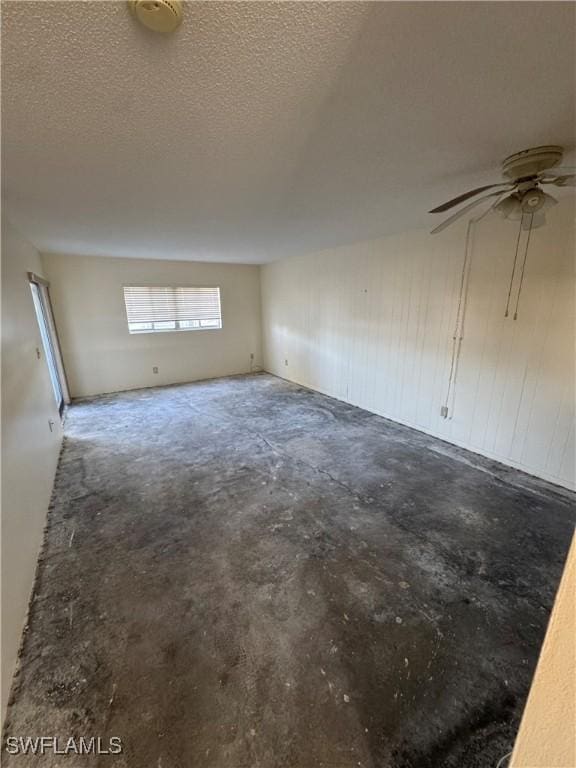 spare room featuring concrete flooring, a textured ceiling, and ceiling fan