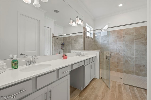 bathroom featuring vanity, a shower with shower door, and crown molding