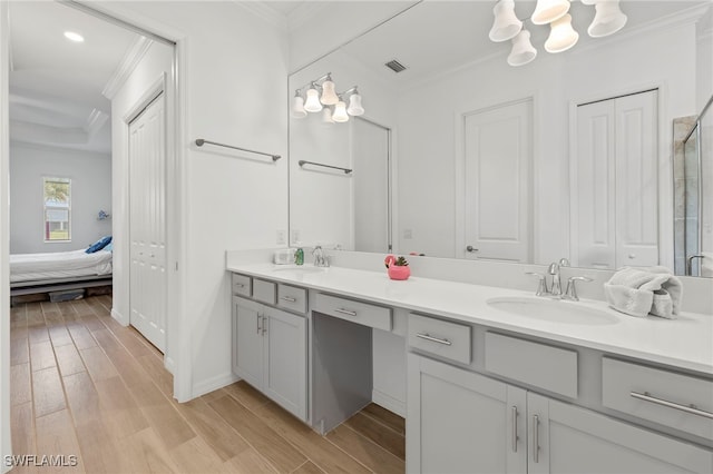 bathroom featuring hardwood / wood-style floors, vanity, a shower with shower door, and ornamental molding