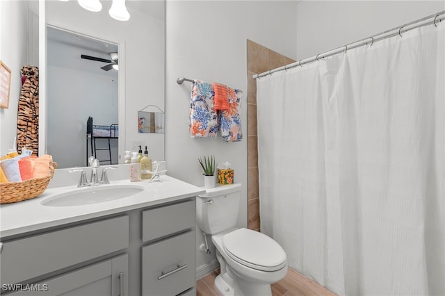 bathroom featuring vanity, hardwood / wood-style flooring, toilet, and ceiling fan