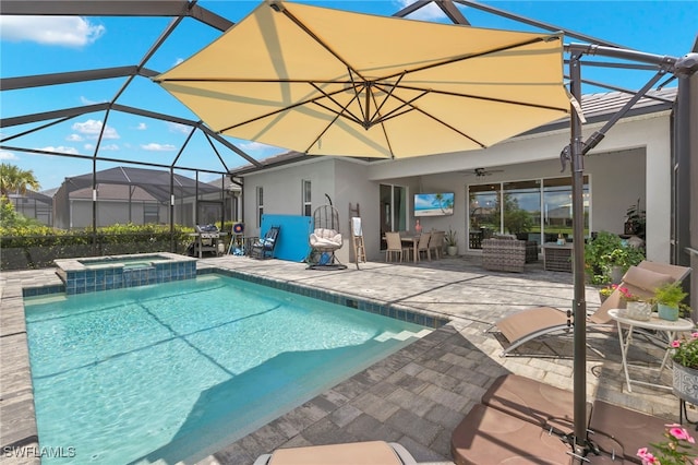 view of pool with a patio area, an in ground hot tub, ceiling fan, and glass enclosure