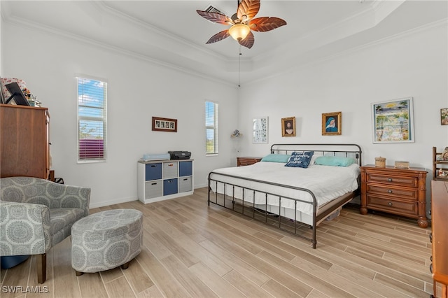 bedroom with ceiling fan, a raised ceiling, and multiple windows