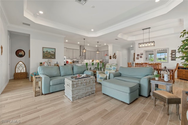 living room with a raised ceiling and ornamental molding