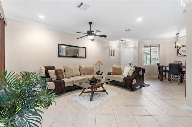 tiled living room featuring ceiling fan with notable chandelier and crown molding