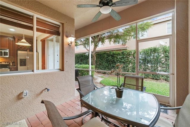 sunroom featuring ceiling fan