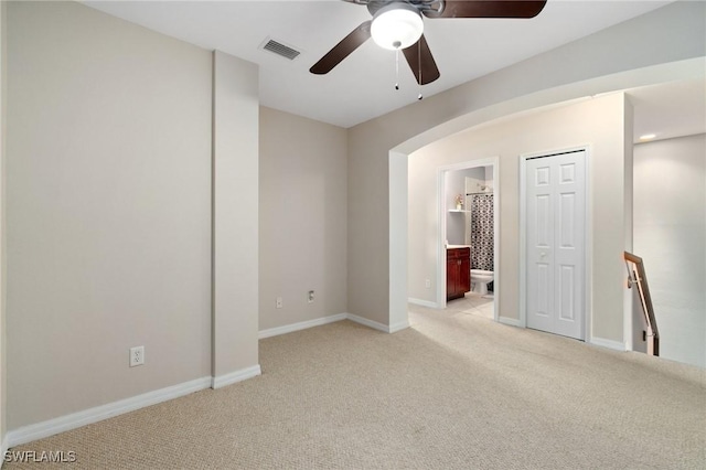 empty room featuring ceiling fan and light carpet