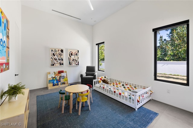 bedroom featuring tile patterned floors and a nursery area