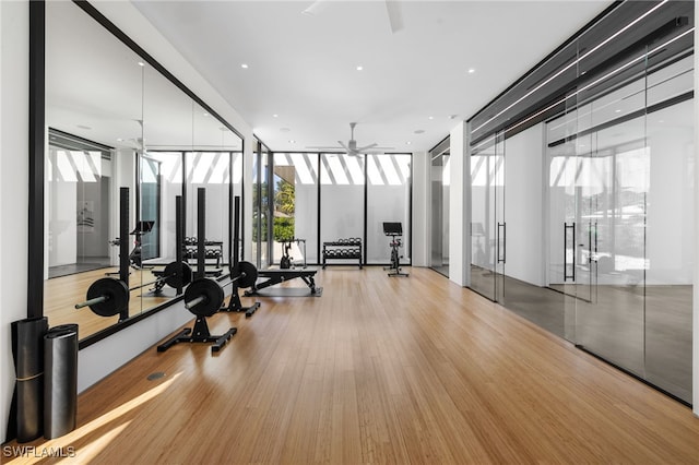 gym featuring ceiling fan, wood finished floors, and floor to ceiling windows