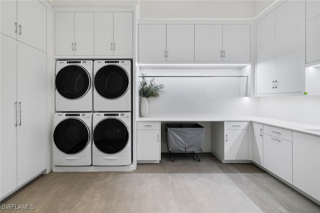 washroom featuring cabinet space, washing machine and dryer, and stacked washing maching and dryer