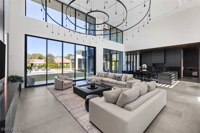 living room with a notable chandelier and concrete floors